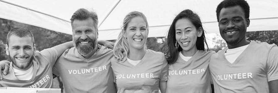 Group of volunteers with arms around each other, smiling